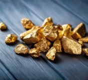 A pile of gold nuggets sitting on top of a wooden table